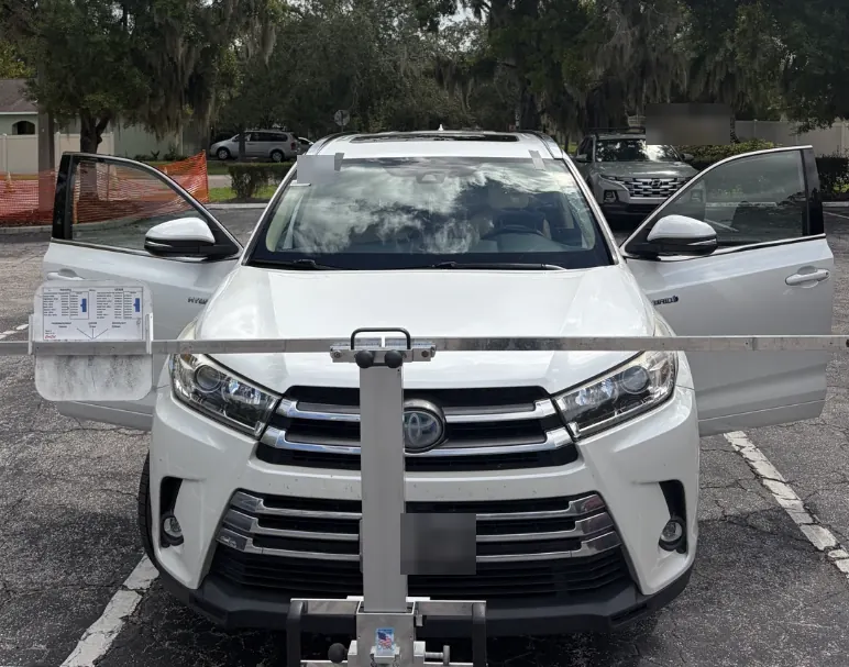 White Toyota Highlander with a camera calibration target set up in front of the vehicle